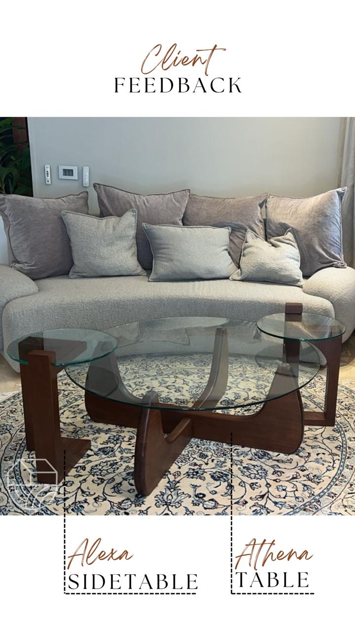 Sofa with cushions and two coffee tables on a patterned rug, Glass coffee table with wooden base in a living room setting