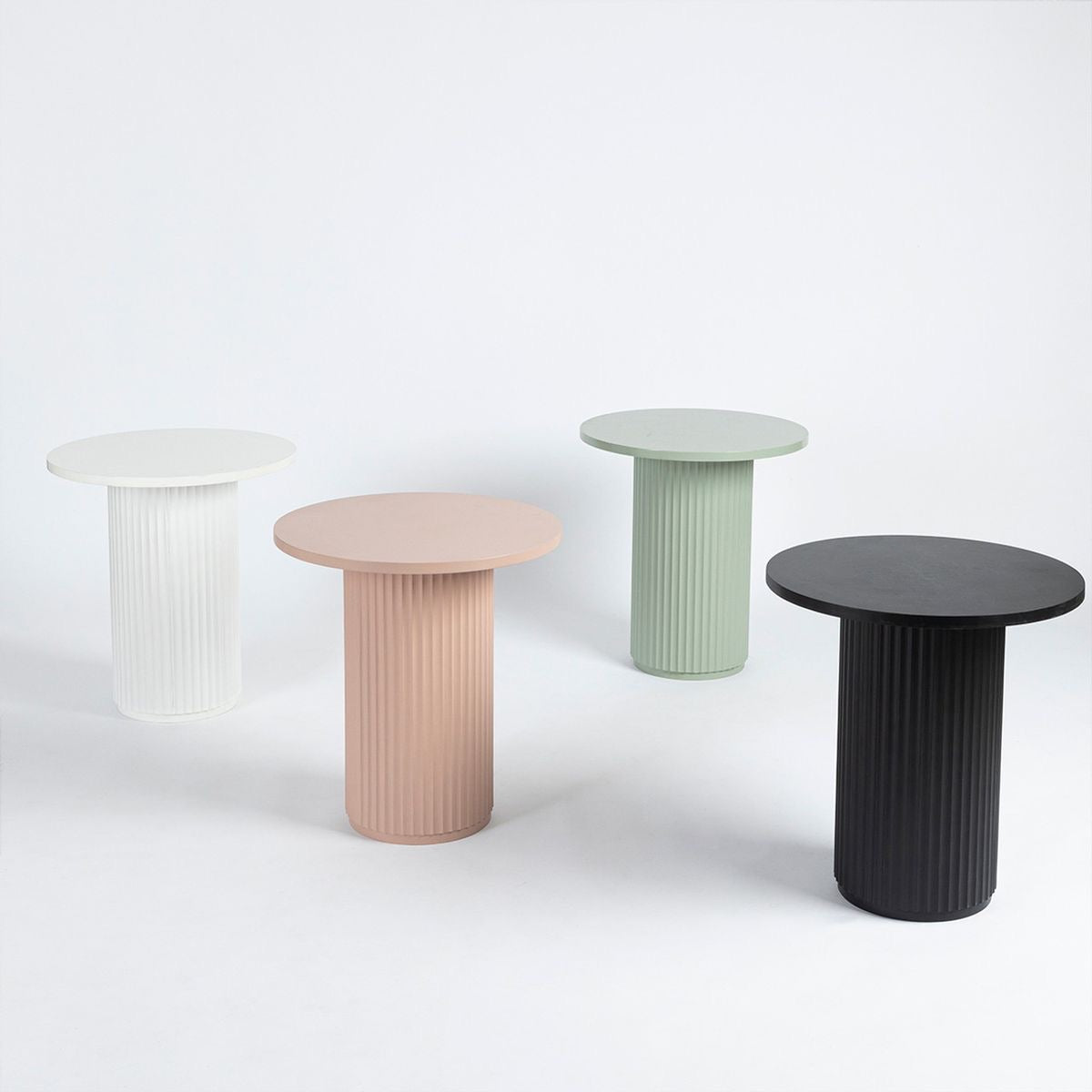 Four small round tables in different colors on a white background