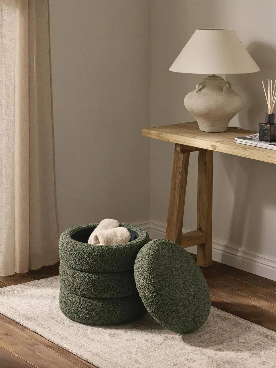 Green textured ottomans in a room with a wooden table and lamp.