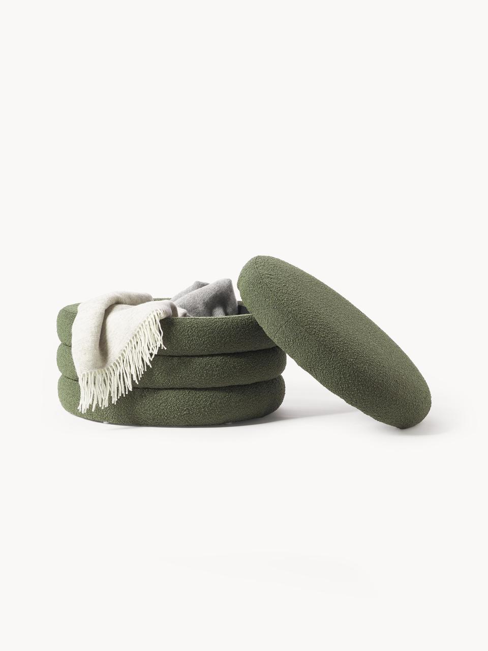 Stack of green fabric rings ottoman  with a white blanket on a white background