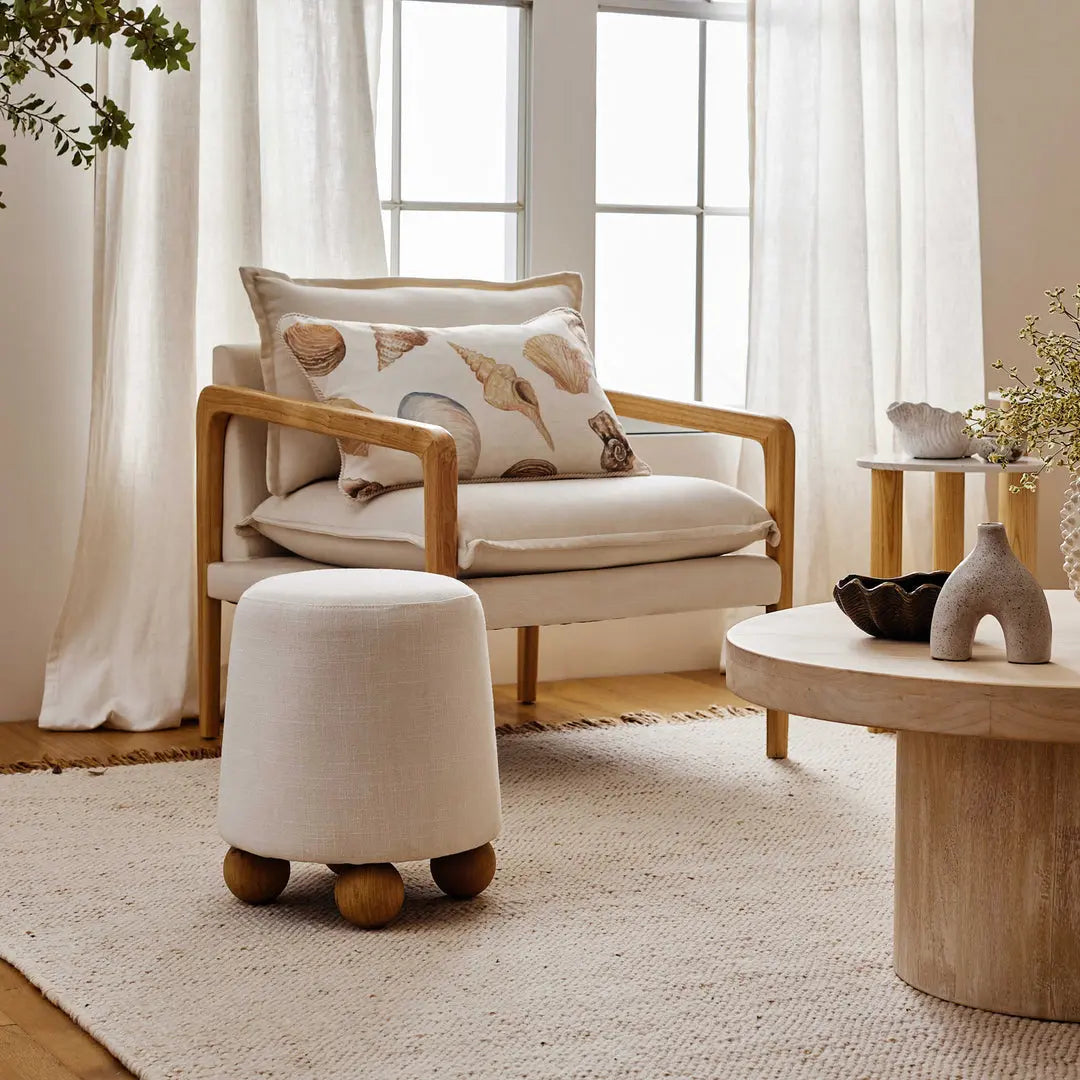 Cozy living room with a wooden armchair, ottoman, and coffee table.