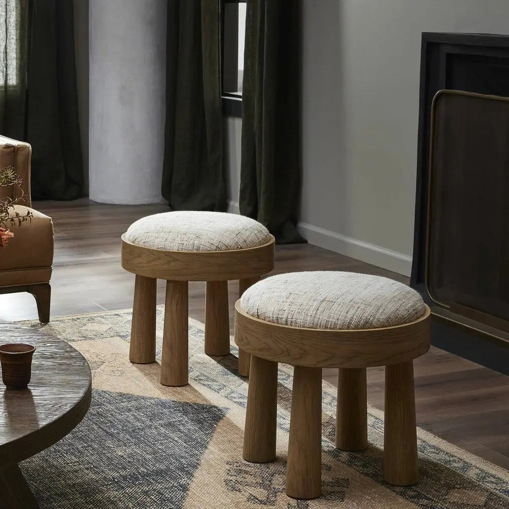 Two wooden stools with cushioned seats in a living room setting.