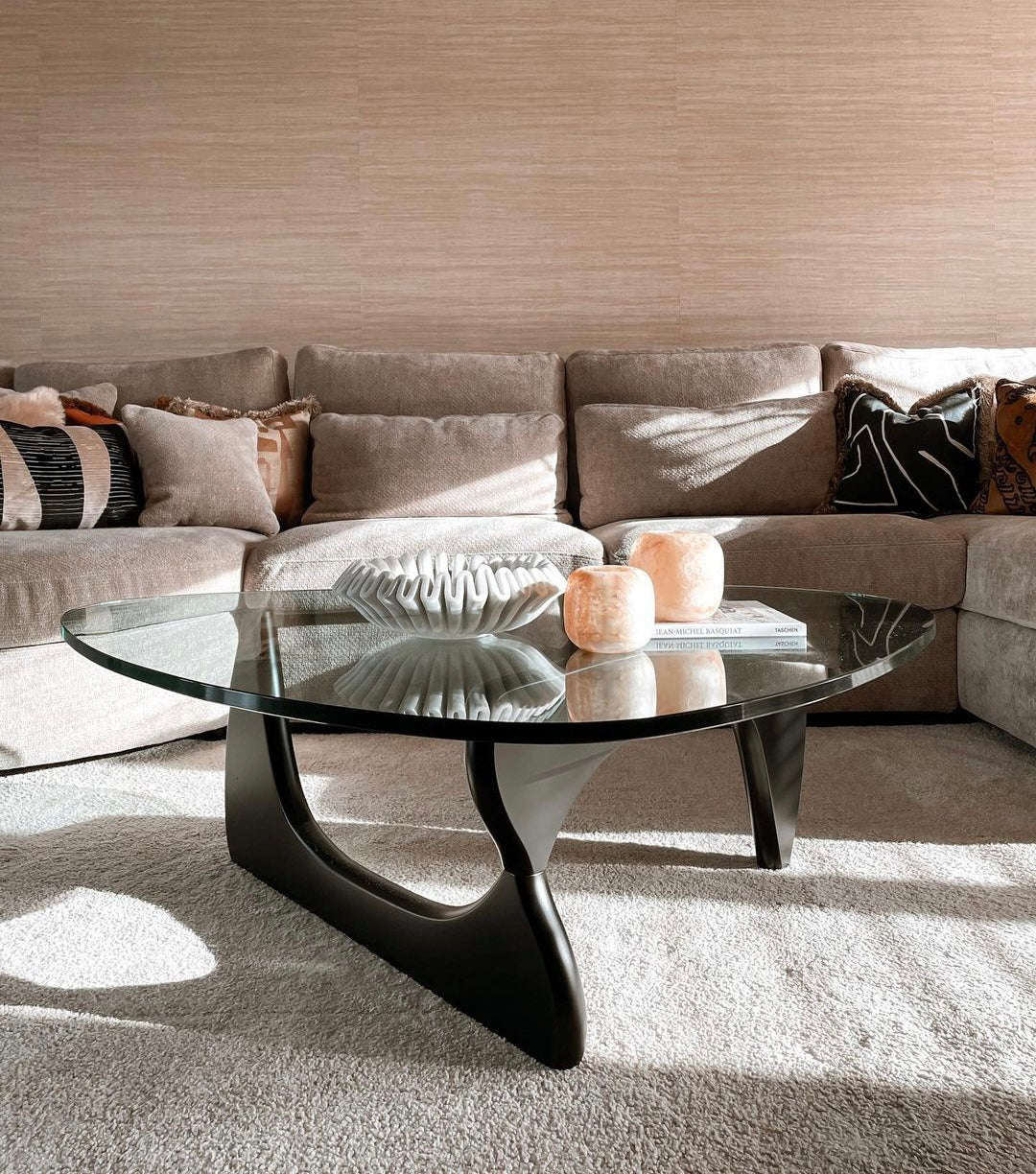 Modern living room with a sectional sofa and glass coffee table.