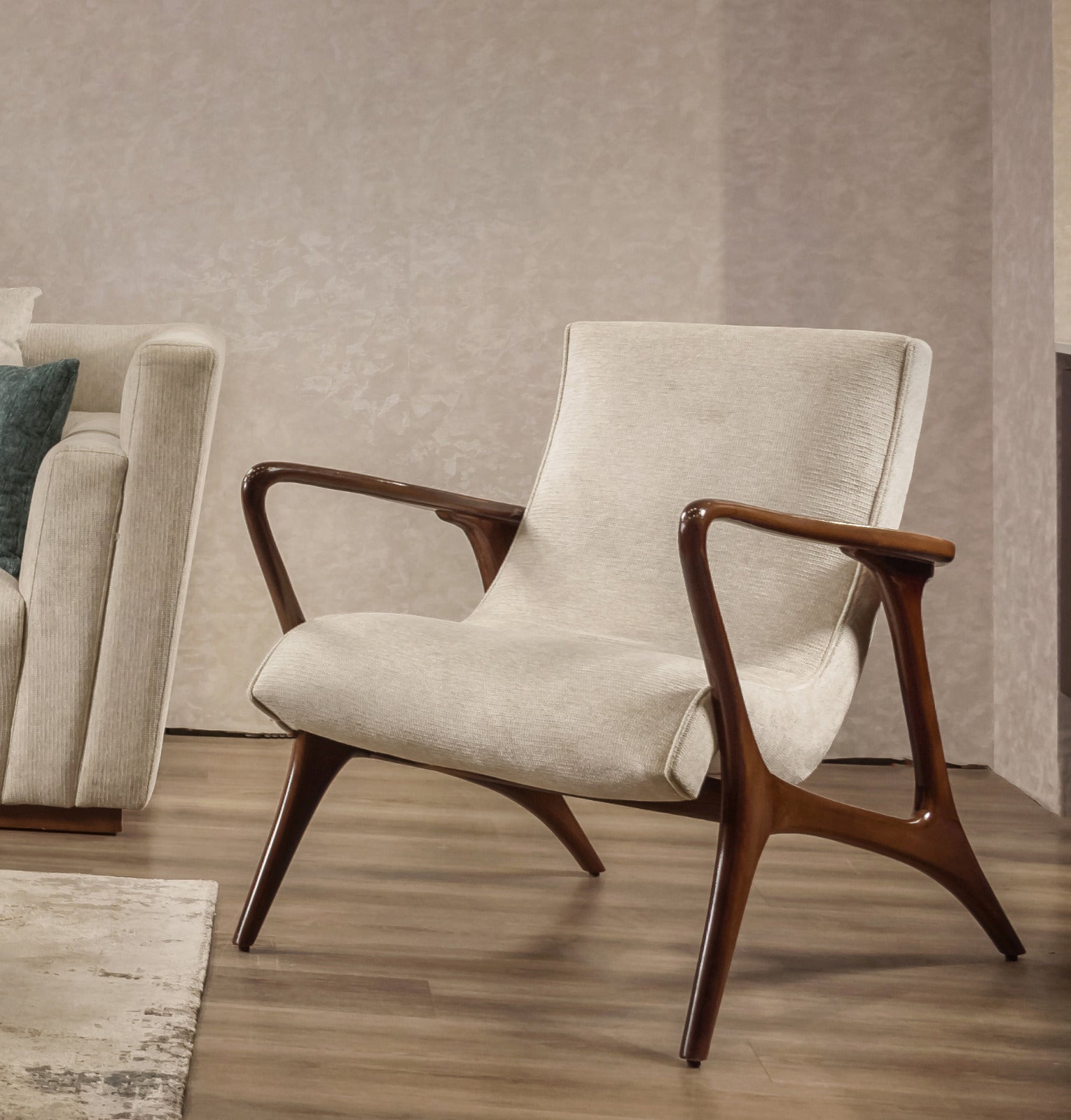 Beige armchair with wooden arms and legs in a living room setting