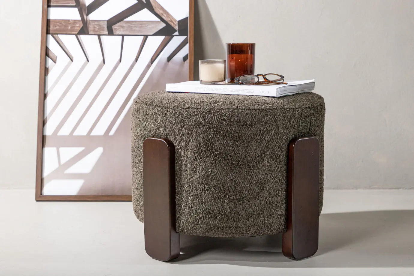 Textured ottoman with wooden legs on a light background