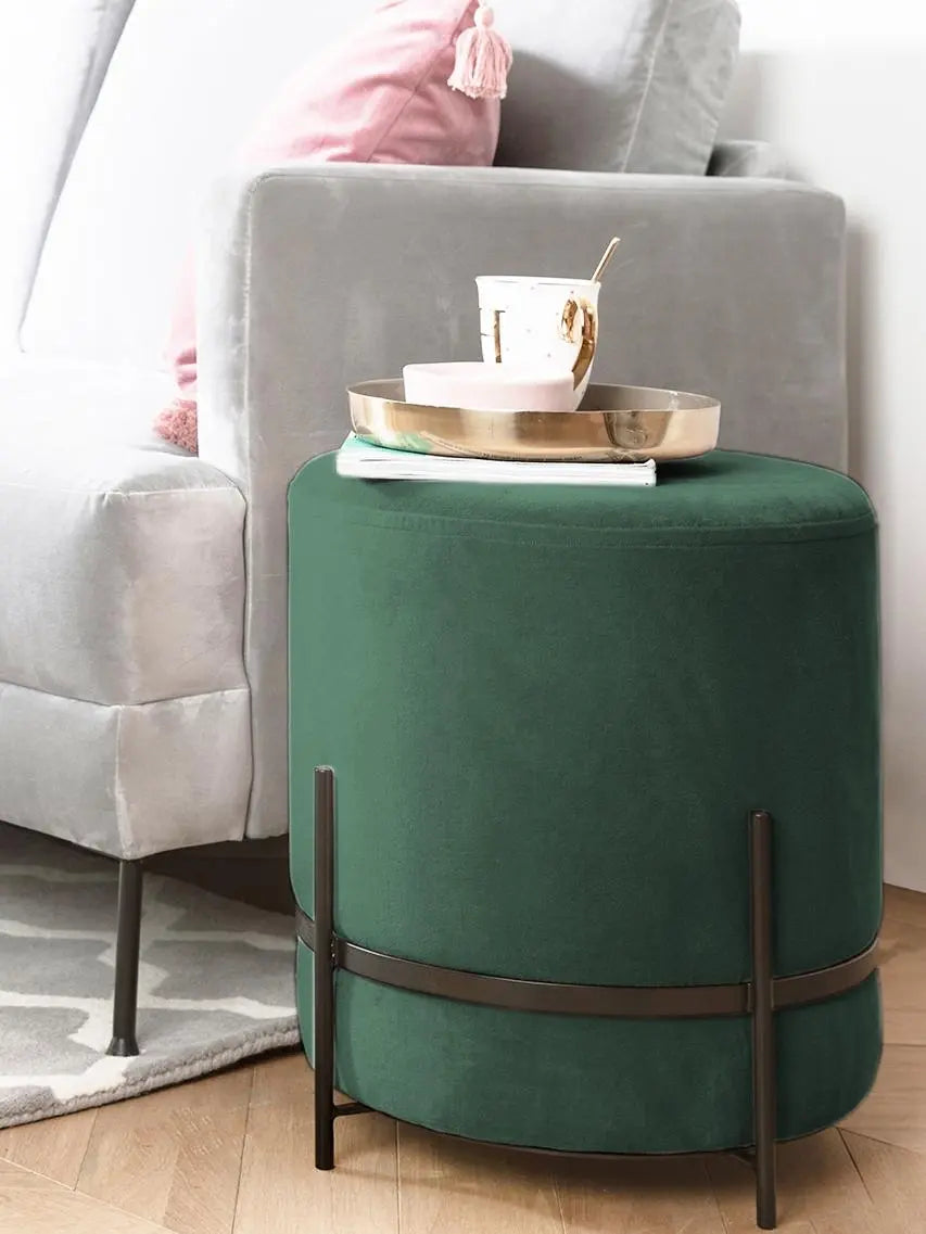 Green ottoman with a tray and cup on a gray sofa in a living room setting
