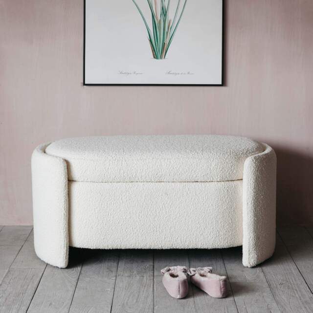 White textured Bench against a pink wall with a framed picture.