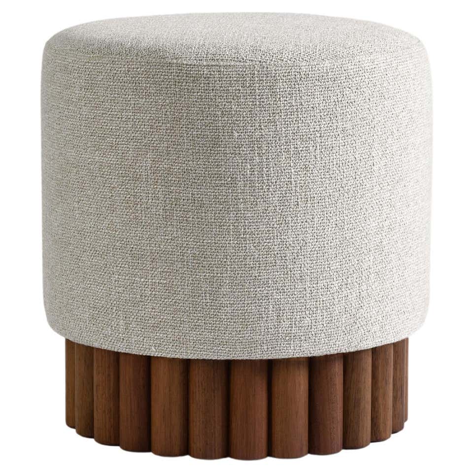 Round ottoman with textured gray cushion and wooden base on a white background