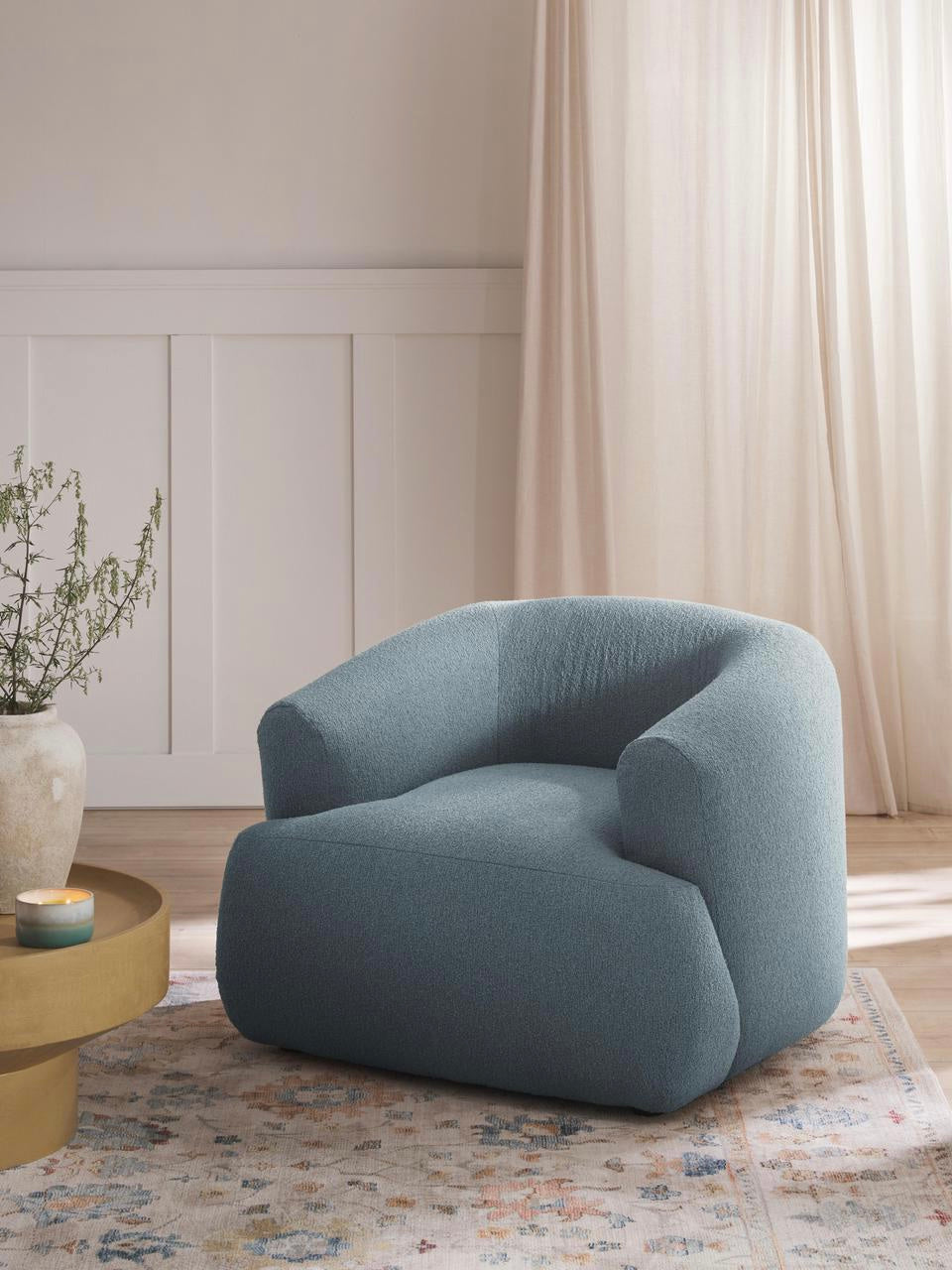 Blue armchair in a living room setting with a neutral color palette