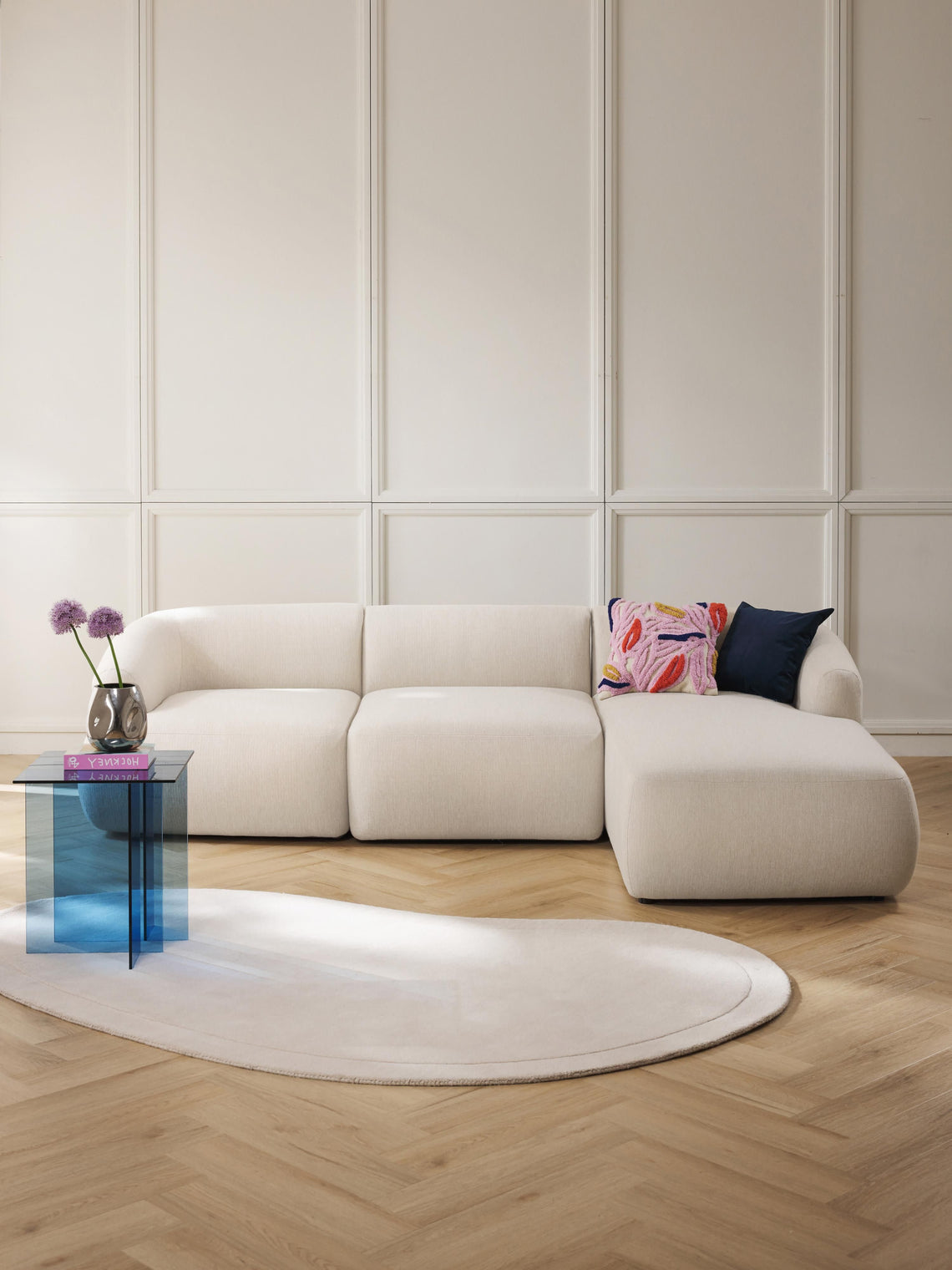 Modern white sofa with colorful pillows in a stylish living room setting.