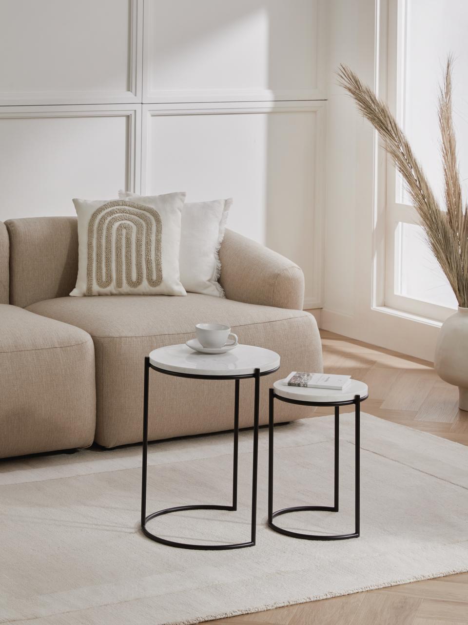 Modern living room with beige sofa, decorative pillows, and side tables.