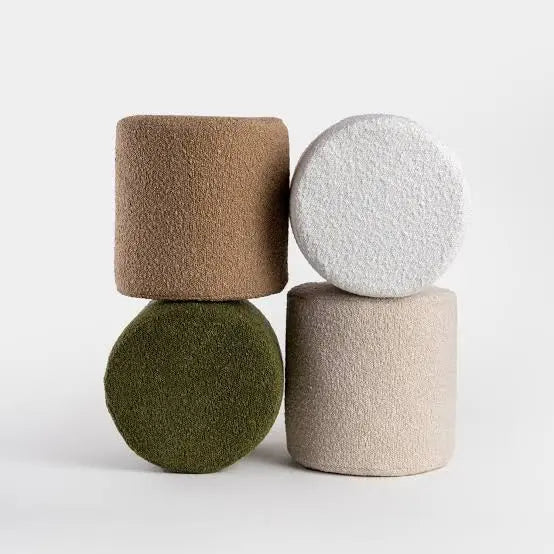 Four textured cylindrical objects in different colors on a light gray background