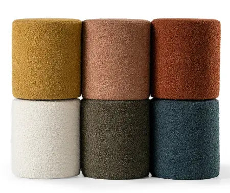 Set of five cylindrical ottomans in various earthy tones on a white background
